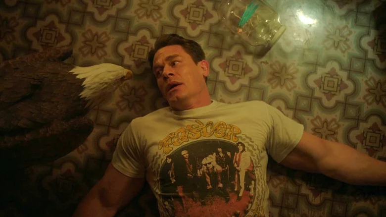 John Cena as Christopher Smith AKA Peacemaker laying on the ground with Eagly in Peacemaker