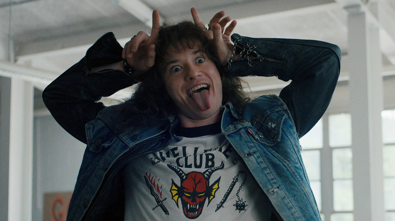 Joseph Quinn as Eddie Munson, giving himself devil horns in Stranger Things