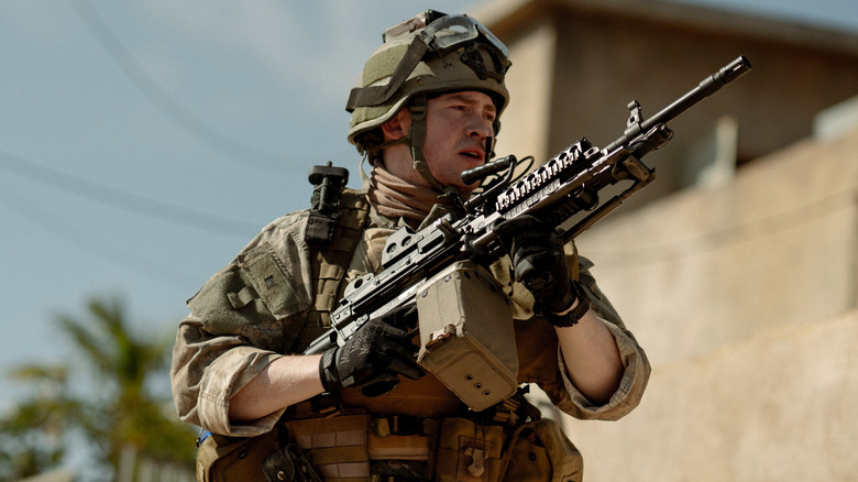 Joseph Quinn as Sam, holding an assault rifle in Warfare