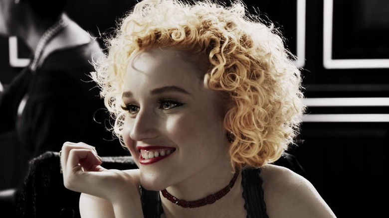Julia Garner as Marcie, smiling at a table in Sin City: A Dame to Kill For