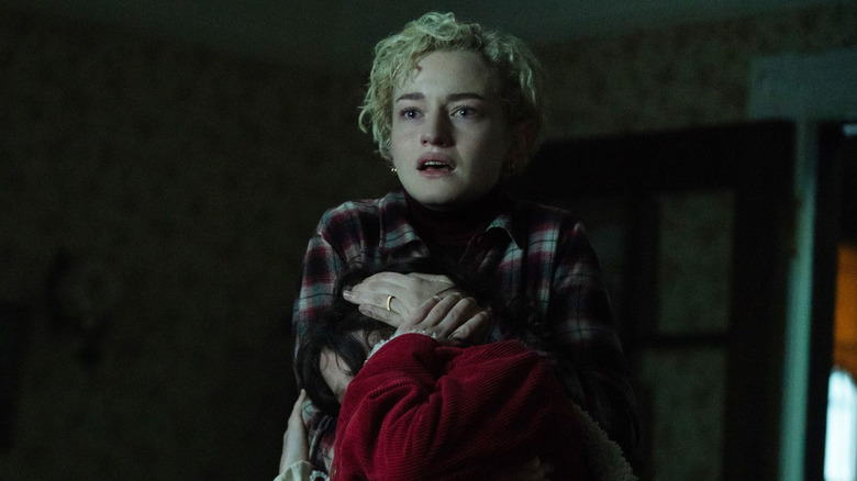 Julia Garner as Charlotte Lovell, holding a child in Wolf Man