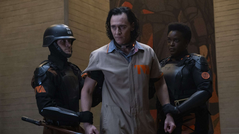 Tom Hiddleston as Loki is detained by TVA agents in Loki