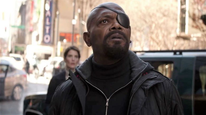 Nick Fury (Samuel L. Jackson) and Maria Hill (Cobie Smulders) look up in shock on a city street in Avengers: Infinity War