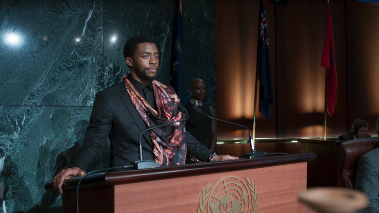 T'Challa (Chadwick Boseman) stands at a podium in Black Panther