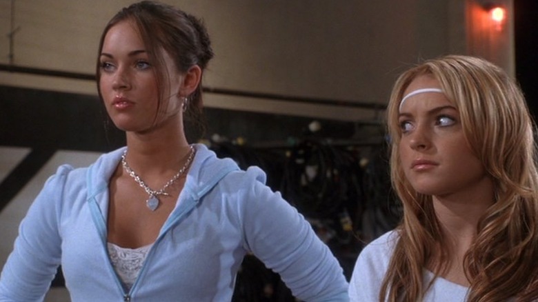 Megan Fox standing in blue sweatshirt as Carla and Lindsay Lohan looking to the side as Lola in Confessions of a Teenage Drama Queen
