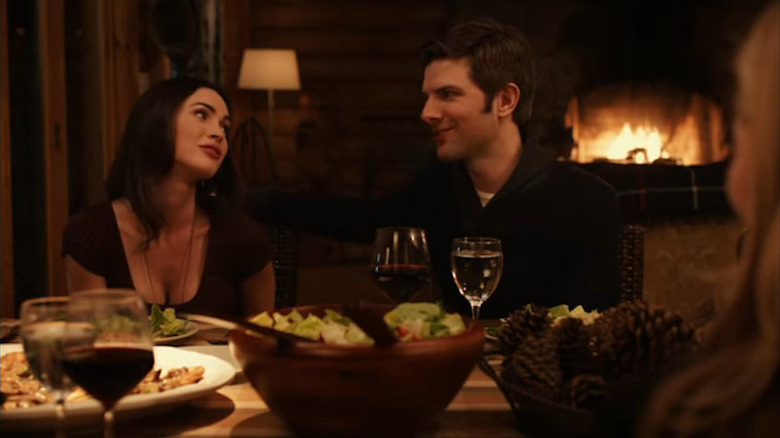 Megan Fox as Mary Jane and Adam Scott as Jason smiling at each other at the dinner table in Friends With Kids