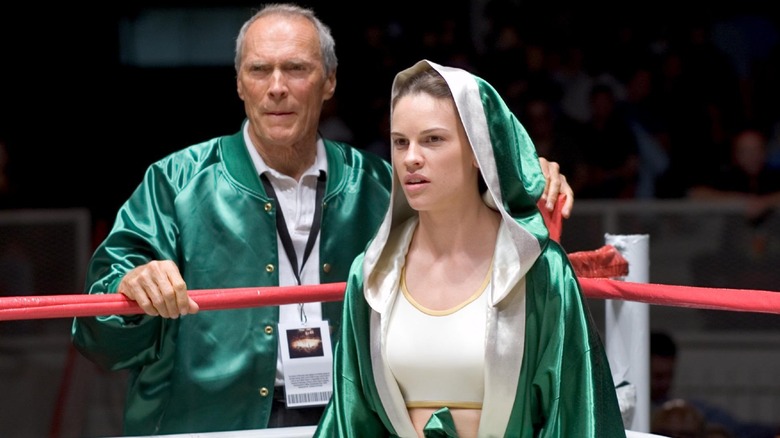 Clint Eastwood as Frankie Dunn and Hilary Swank as Maggie Fitzgerald, as Maggie stands in the ring with Frankie on the other side of the ropes behind her.