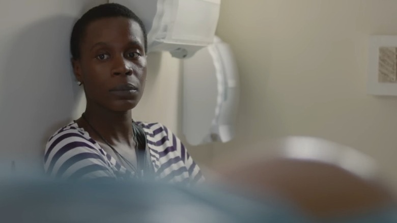 Isabél Zuaa as Clara sitting next to the hospital bed of Marjorie Estiano as a pregnant Ana in Good Manners