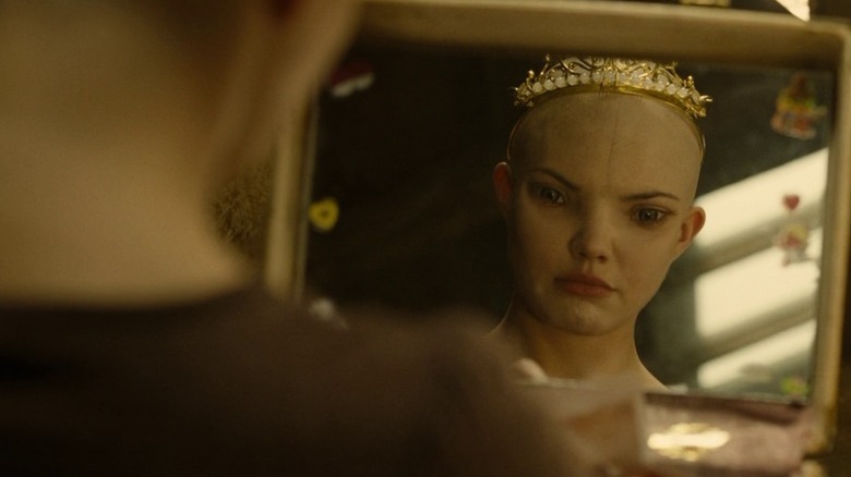 Delphine Chanéac as Dren wearing a tiara and looking at herself in a mirror in Splice