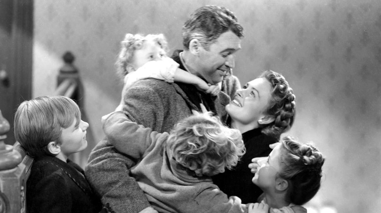 James Stewart as George Bailey, being embraced by his family in It's a Wonderful Life.