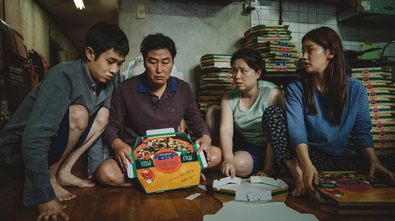 The Kim family huddles around pizza boxes in Parasite.