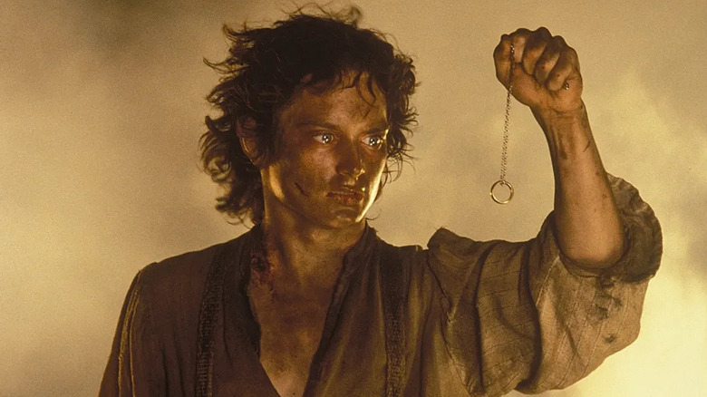 Elijah Wood as Frodo Baggins, dangling the One Ring in front of his eyes in The Lord of the Rings: Return of the King.