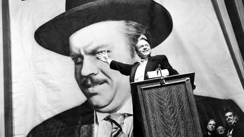 Orson Welles as Charles Foster Kane in Citizen Kane, giving a speech in front of a giant poster of himself