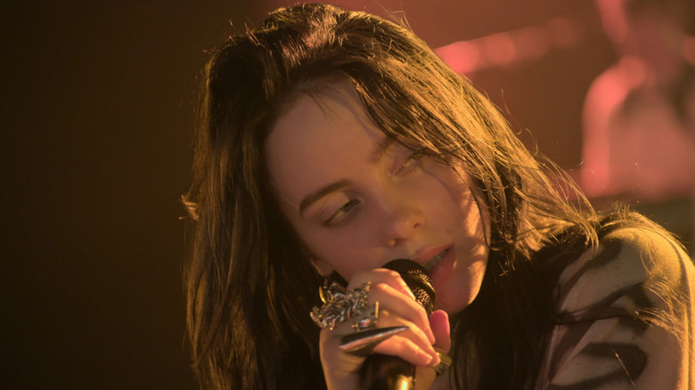 Billie Eilish, mic in hand and performing in Billie Eilish: The World's a Little Blurry.