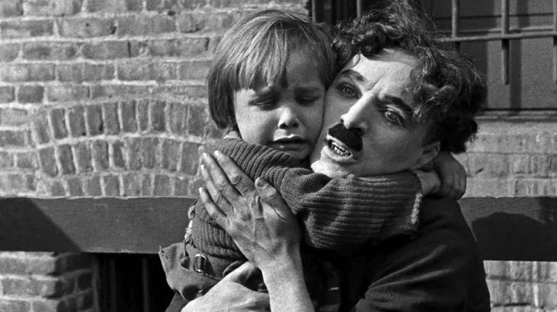 Charlie Chaplin as the Tramp, hugging the crying Kid in The Kid
