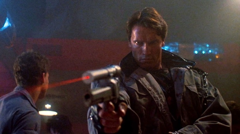 Arnold Schwarzenegger as the Terminator, aiming a laser pistol in The Terminator