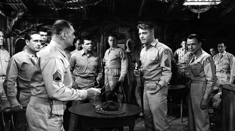 In a crowded bar of soldiers, Burt Lancaster as First Sergeant Milton Warden and Frank Sinatra as Private Angelo Maggio face off against Ernest Borgnine as Staff Sergeant James Judson in From Here to Eternity.
