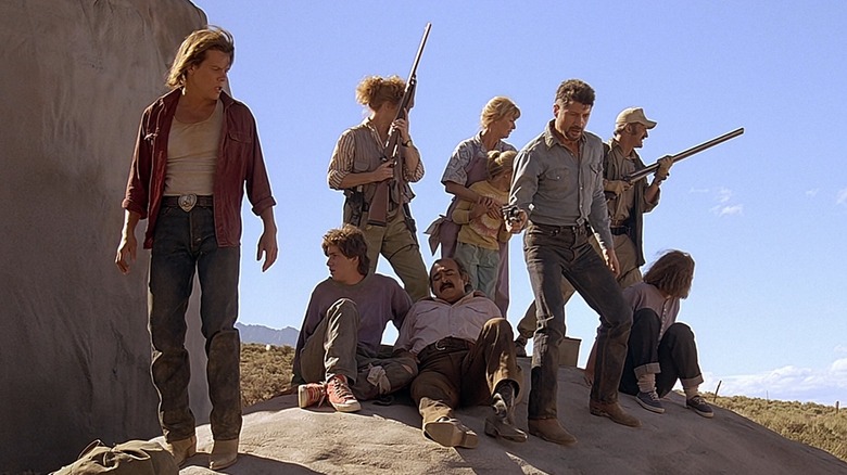 Val (Kevin Bacon), Earl (Fred Ward), and crew perch on a rock in Tremors