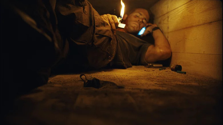 Paul Conroy uses a lighter to examine sand in his coffin in Buried