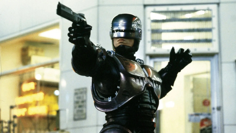 Peter Weller as RoboCop, aiming a gun in the 1987 movie RoboCop