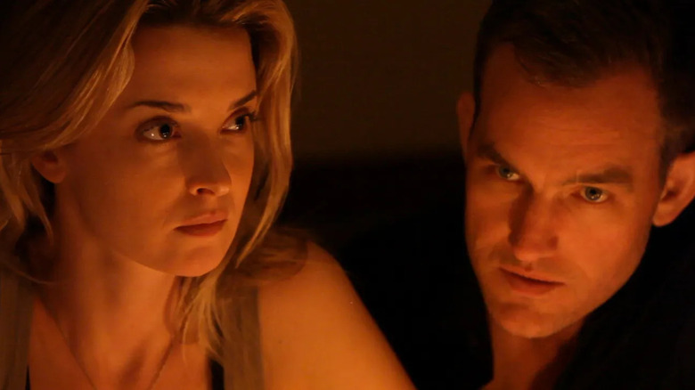 Emily Baldoni as Em staring intensely next to Maury Sterling as Kevin in Coherence.