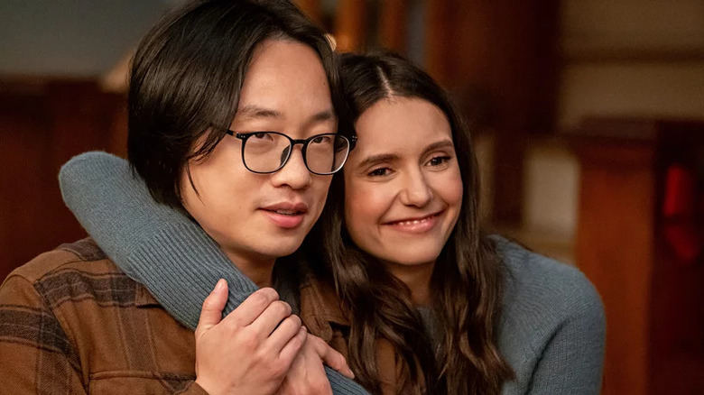 Jimmy O. Yang and Nina Dobrev as Josh Lin and Natalie Bauer showing affection in front of his family in Love Hard