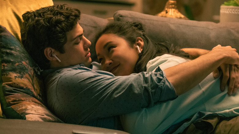 Noah Centineo and Lana Condor as Peter Kavinsky and Lara Jean Covey cuddle on the couch while listening to music in To All The Boys I've Loved Before