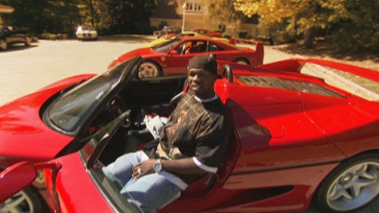 50 Cent sits in a parked Ferrari in MTV Cribs