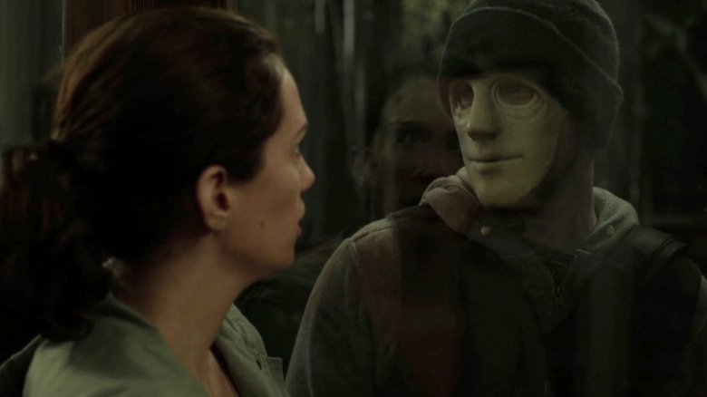 The Killer (John Gallagher Jr.) looking through window at Maddie (Kate Siegel) in Hush