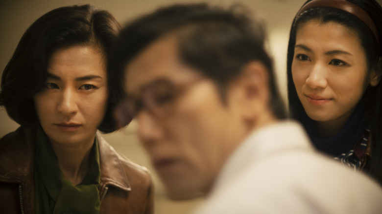 Machiko Ono as Makiko Satomi and Suzu Hirose as Sakiko Takezawa staring intently at Masahiro Motoki as Takao Satomi in Asura