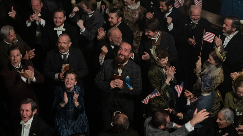 Charles Guiteau (Matthew Macfadyen) looks up adoringly in a crowd of smiling supporters in Death By Lightning