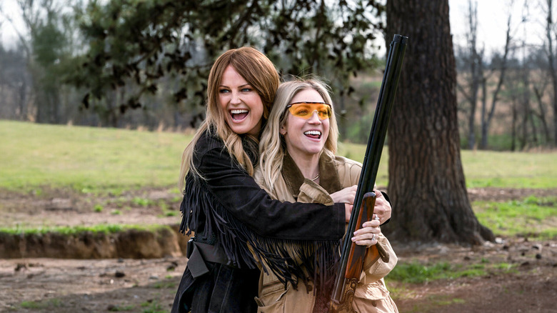 Margo hugging Sophie (who's holding a rifle) on The Hunting Wives