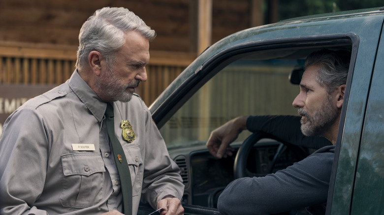 Sam Neill's Paul Souter in a park ranger uniform and Eric Bana's Kyle Turner sitting in a car on Untamed