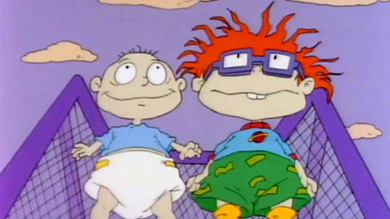 E. G. Daily as Tommy Pickles and Nancy Cartwright as Chuckie Finster in Rugrats, standing against a blue and cloudy sky.