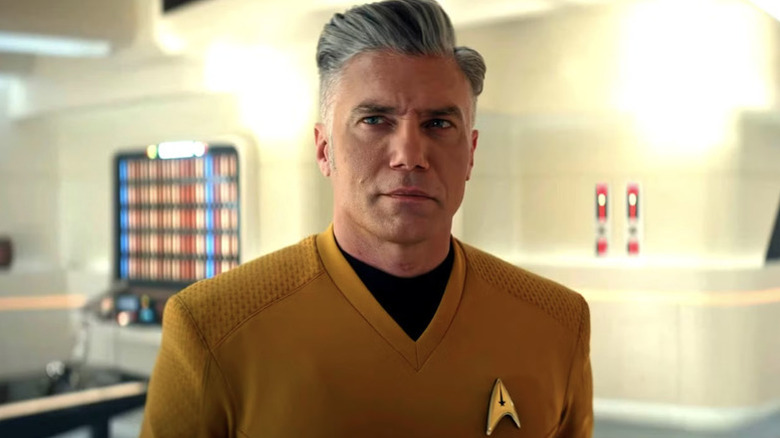 Christopher Pike (Anson Mount) stands confidently in a brightly lit room in Star Trek: Strange New Worlds