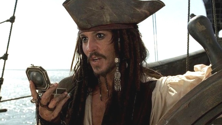 Jack Sparrow (Johnny Depp) checks a compass in Pirates of the Caribbean: The Curse of the Black Pearl