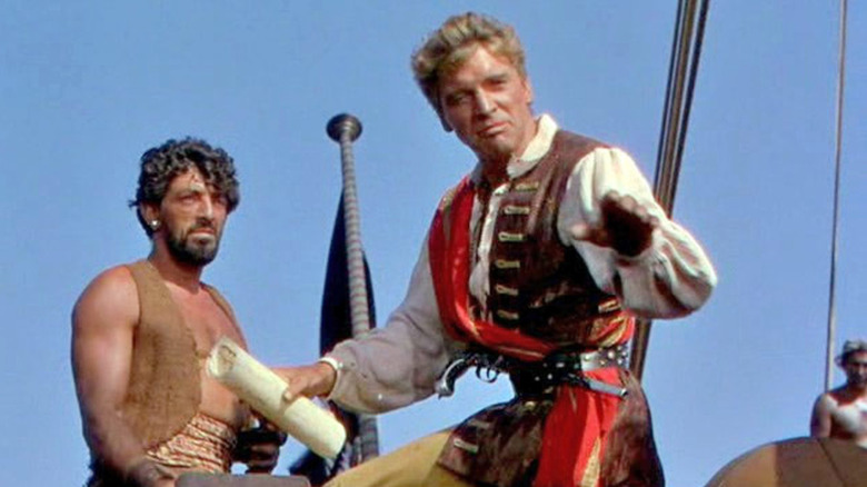 Ojo (Nick Cravat) watches as Vallo (Burt Lancaster) speaks to his crew in The Crimson Pirate