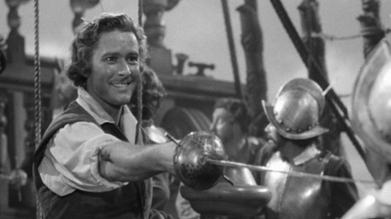 Geoffrey Thorpe (Errol Flynn) grins while holding out his sword in The Sea Hawk (1940)