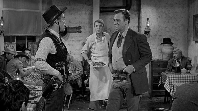 John Wayne as Tom Doniphon talks to a man in a diner in The Man Who Shot Liberty Valance