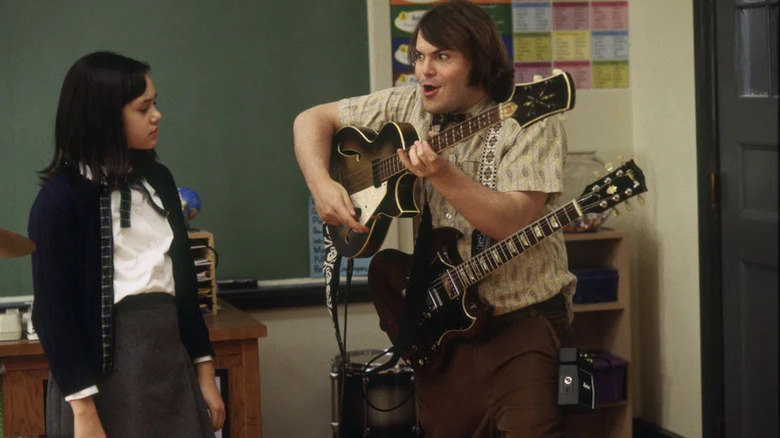 Katie (Rivkah Reyes) watches Dewey Finn (Jack Black) play a bass guitar in School of Rock
