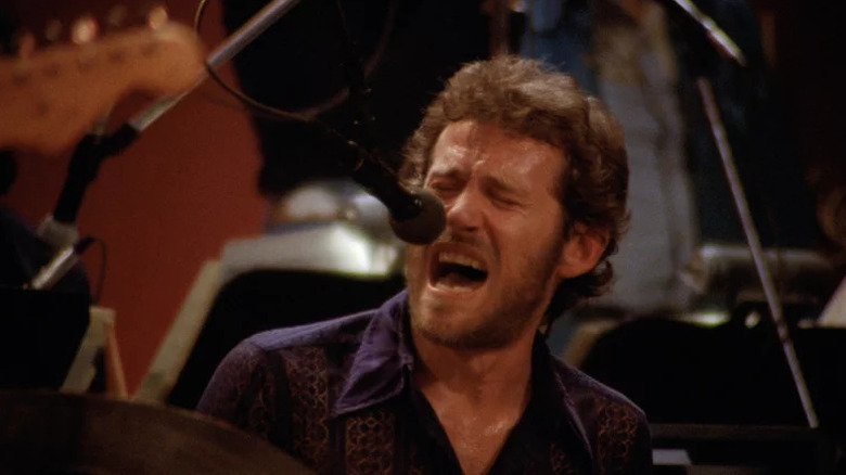 Levon Helm sings passionately into a microphone in The Last Waltz