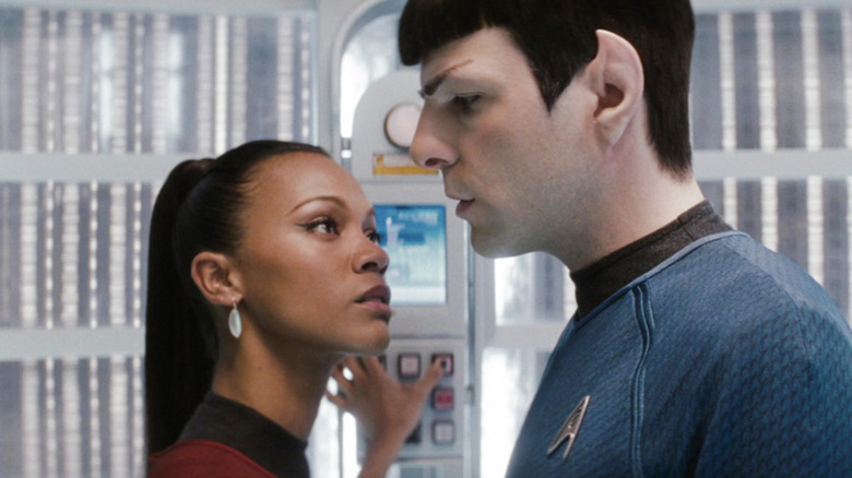 Zoe Saldaña as Nyota Uhura standing in an elevator pressing buttons and starring passionately at Zachary Quinto as Spock in Star Trek (2009)