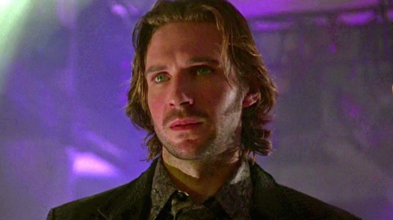 Lenny Nero (Ralph Fiennes) stands in a nightclub in Strange Days