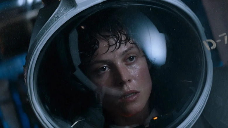 Sigourney Weaver as Ripley in Alien, looking sweaty and worn out in a space helmet.