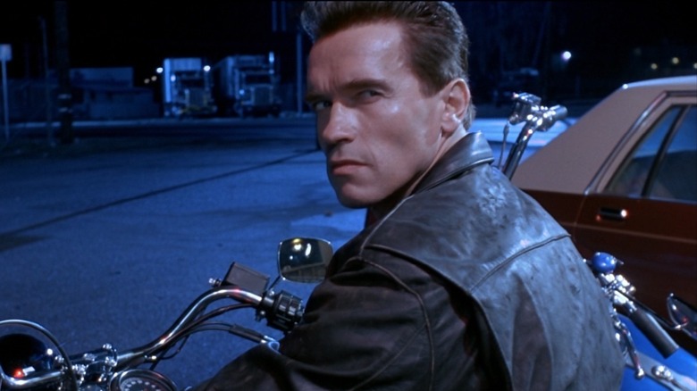 Arnold Schwarzenegger as the Terminator in Terminator 2: Judgment Day, sitting on a motorbike and looking at someone over his shoulder behind the camera.
