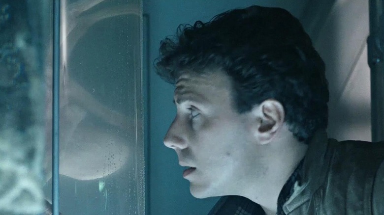 Carter Burke (Paul Reiser) studies a facehugger in stasis in Aliens