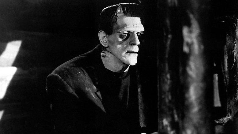 Frankenstein's monster (Boris Karloff) peers from around a corner in Frankenstein (1931)
