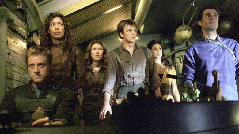Mal Reynolds (Nathan Fillion) and the Firefly crew stand on the ship's bridge