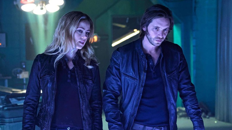Cassie Railly (Amanda Schull) and James Cole (Aaron Stanford) stand over a table in a dimly lit room in 12 Monkeys