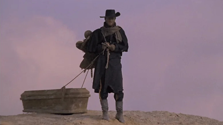 Django (Franco Nero) walks through a desert dragging a coffin in Django (1966)